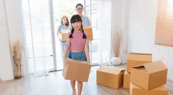 Family of 3 moving in a house with boxes